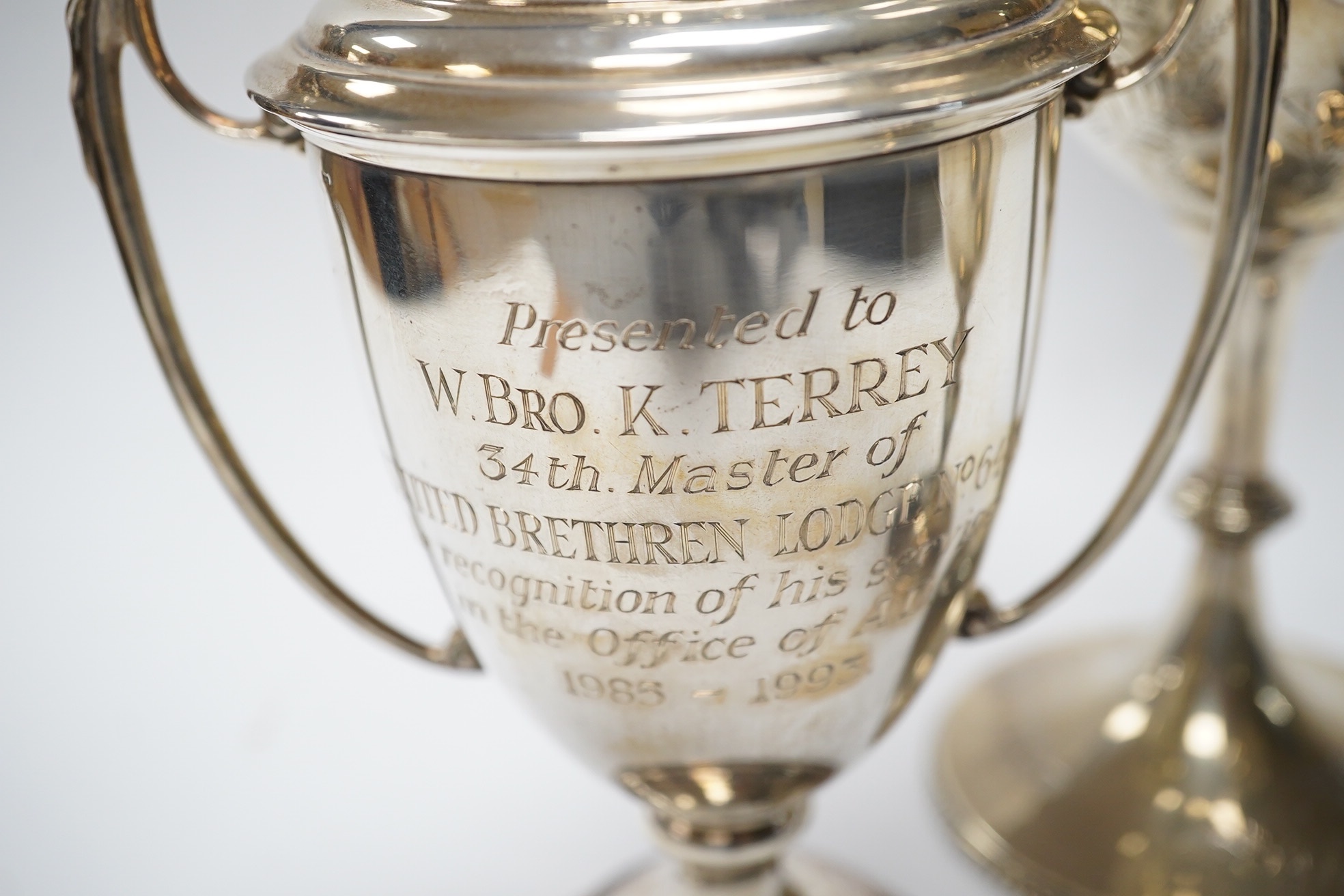 A Victorian engraved silver presentation goblet, with Masonic inscription, London, 1880, 19.5cm, together with a modern silver presentation goblet and a silver two handled presentation trophy cup and cover, 20.2oz. Condi